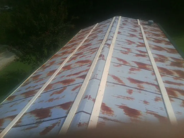 Rusted metal roof panels with new wood purlins before replacement — Storm Damage Roof Repair in Winthrop Harbor by Roofing Brothers