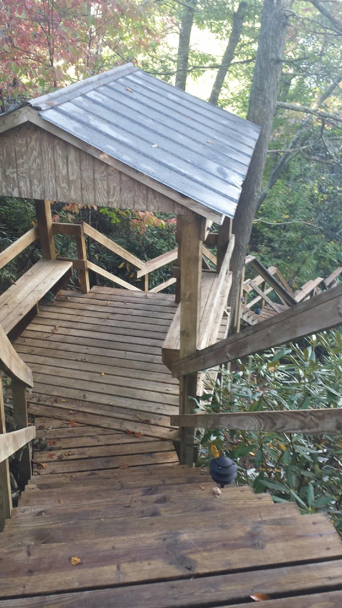 Metal roofed shelter over wooden steps on a wooded walkway — Skylight Repair & Installation work by our crew in Winthrop Harbor